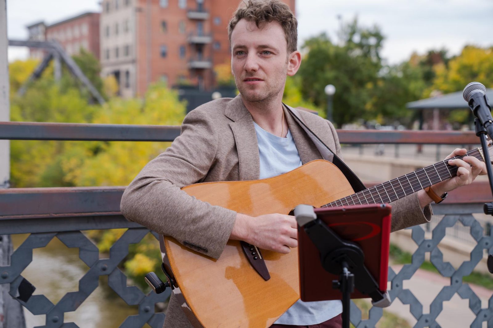 A guitarist playing an acoustic set on a Denver bridge.