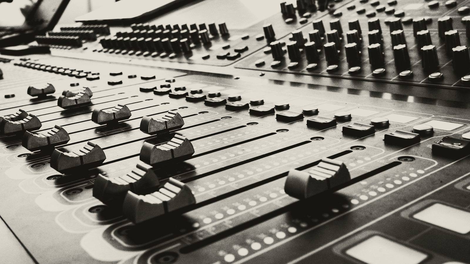Faders and knobs on a mixing console.