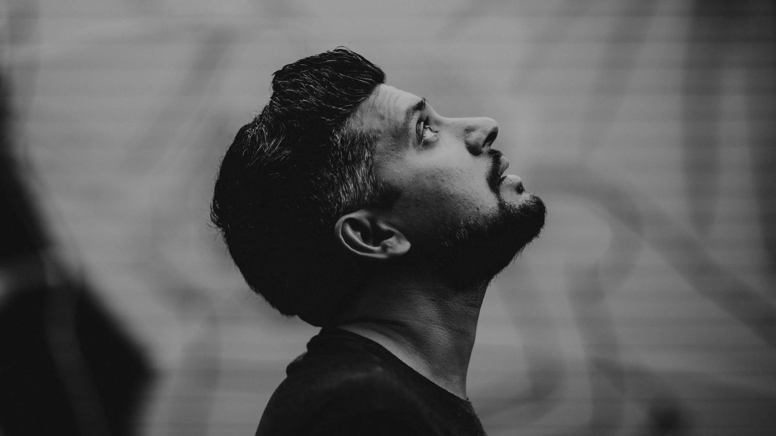 Tejas Singh in profile, looking upward, in black and white.