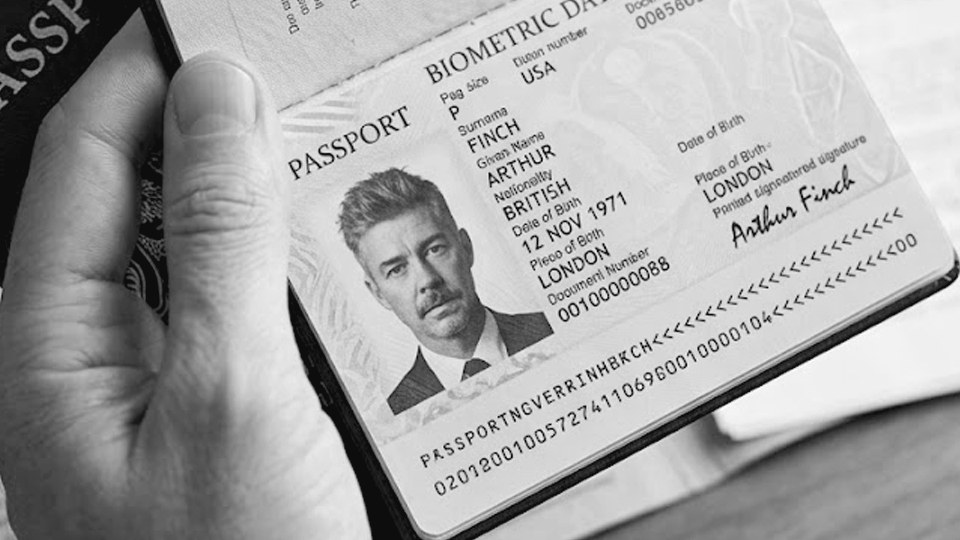 A passport held open at its photo page, in black and white.