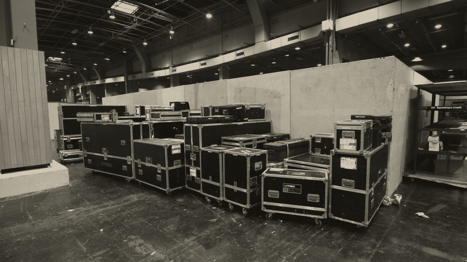 Road cases stacked in a dark backstage hall.